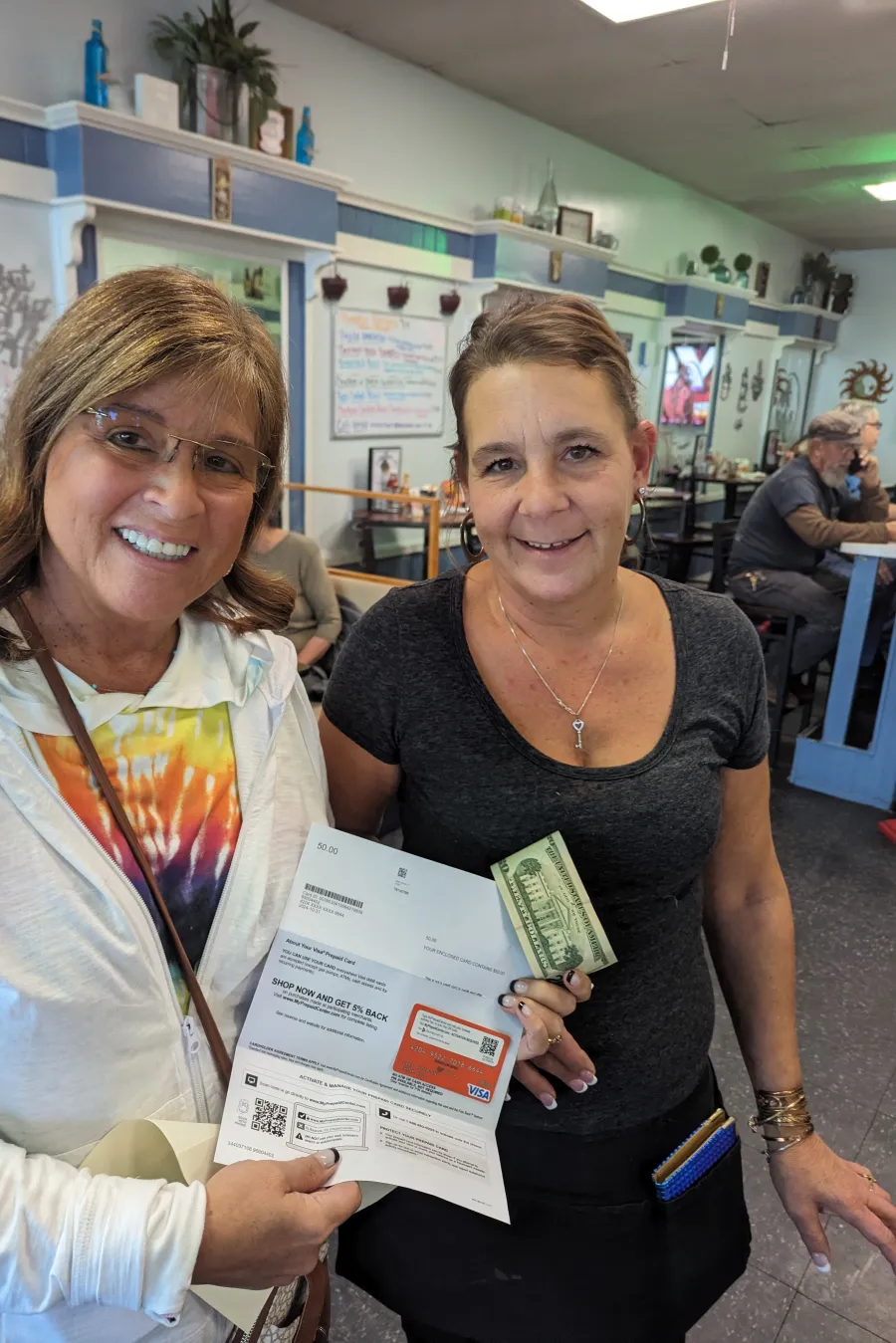 a couple of women holding a piece of paper