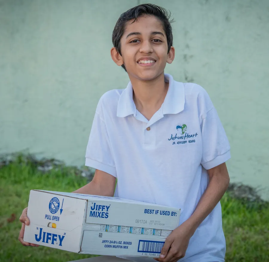 A young volunteer helps load supplies for Joshua's Heart Foundation.