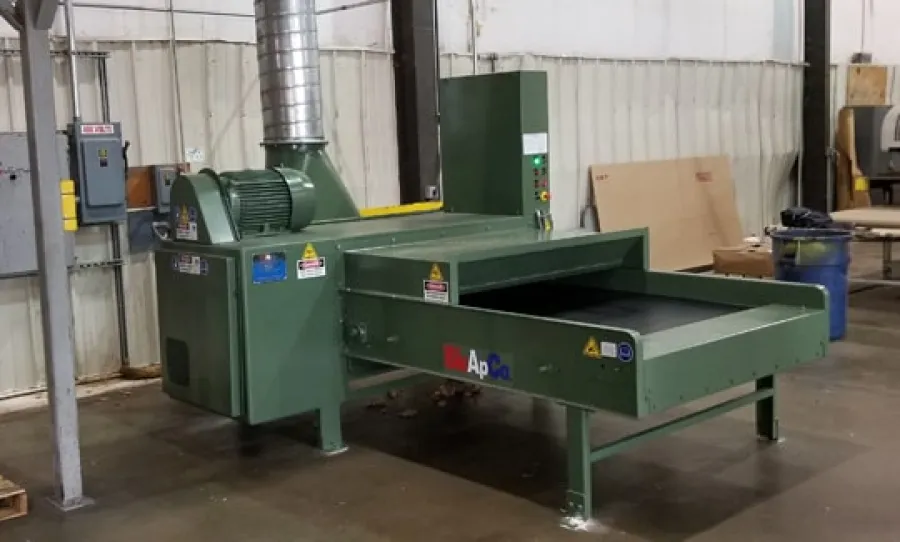 Green industrial Apco conveyor dryer machine in a factory setting with metal duct and control panel.