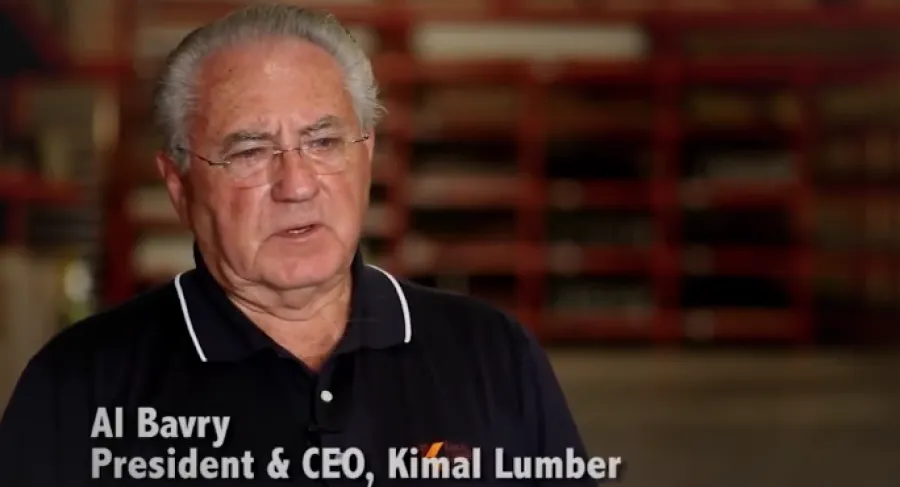Al Bavry, President and CEO of Kimal Lumber, speaking in a warehouse setting with shelves in the background