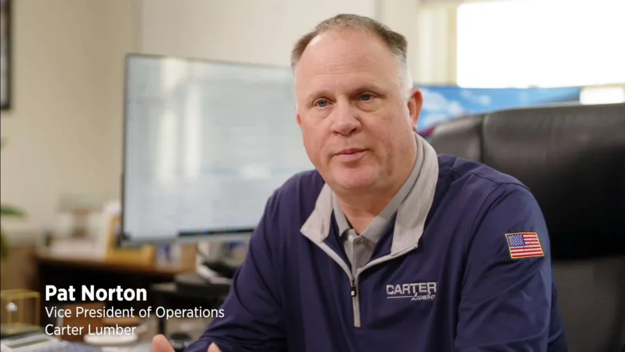 Portrait of Pat Norton, Vice President of Operations at Carter Lumber, sitting in office with company logo blouse.