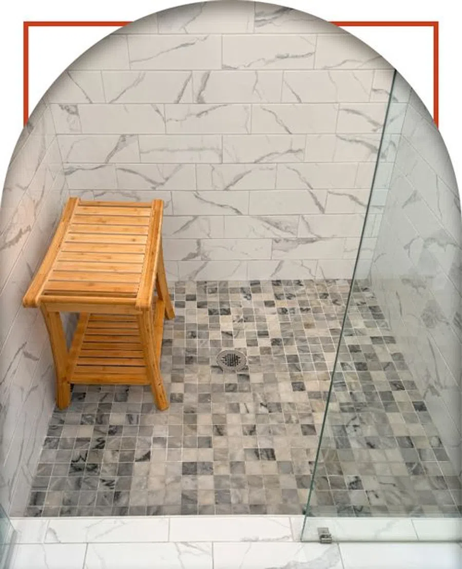 Modern walk-in shower with white marble wall tiles, mosaic floor, glass door, and wooden bench seat
