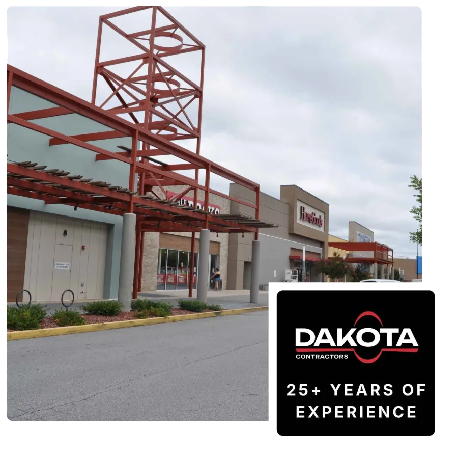 Exterior of a shopping center with HomeGoods and other stores under a cloudy sky with red metal frameworks.