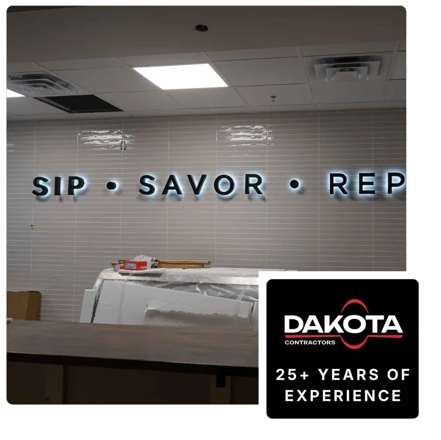 Backlit wall sign reading SIP • SAVOR • REP with construction materials nearby in an indoor space.