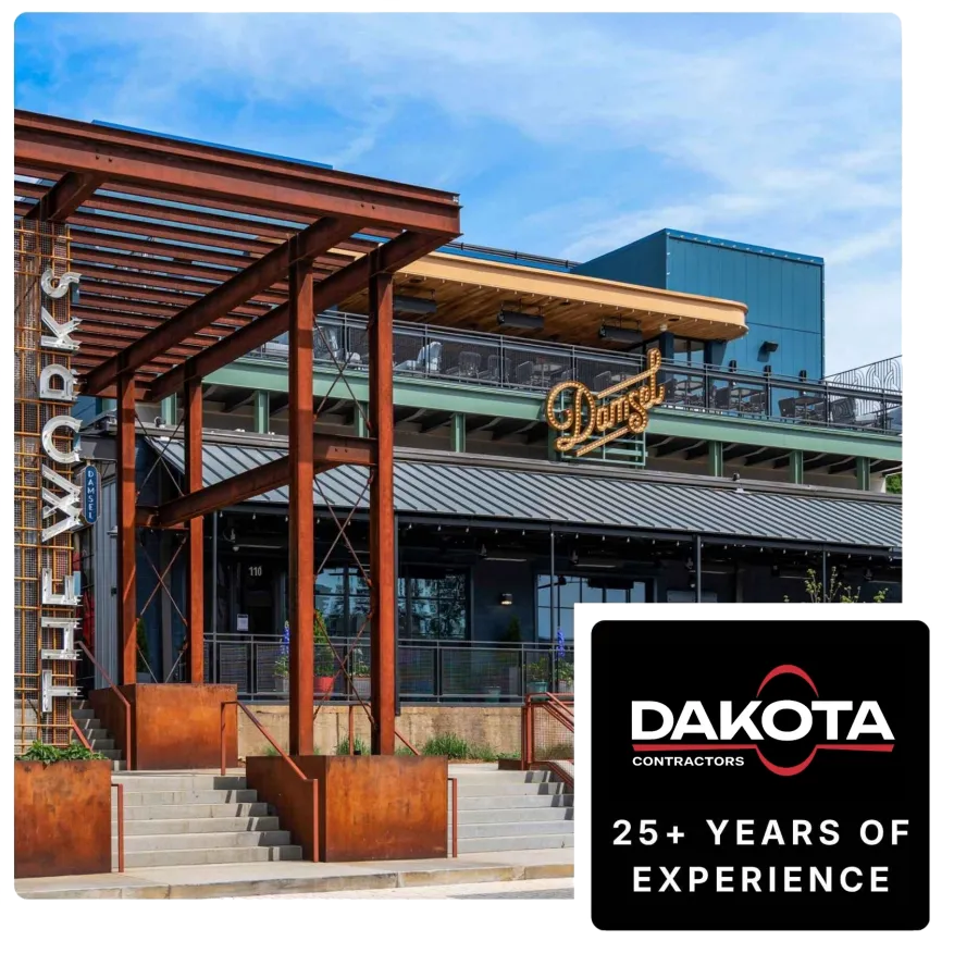 Exterior view of The Fixworks building with rust-colored metal beams and signage under a blue sky.