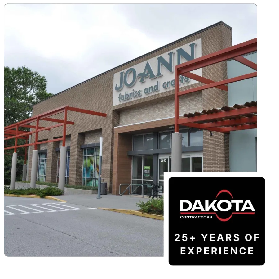 Exterior view of Jo-Ann Fabrics and Crafts store with brick facade and red metal awnings on a cloudy day