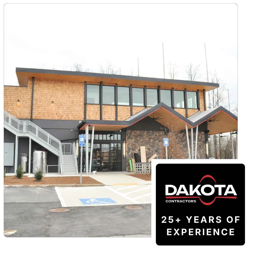 Modern commercial building with wood siding, large windows, stone accents, and handicap parking in front.