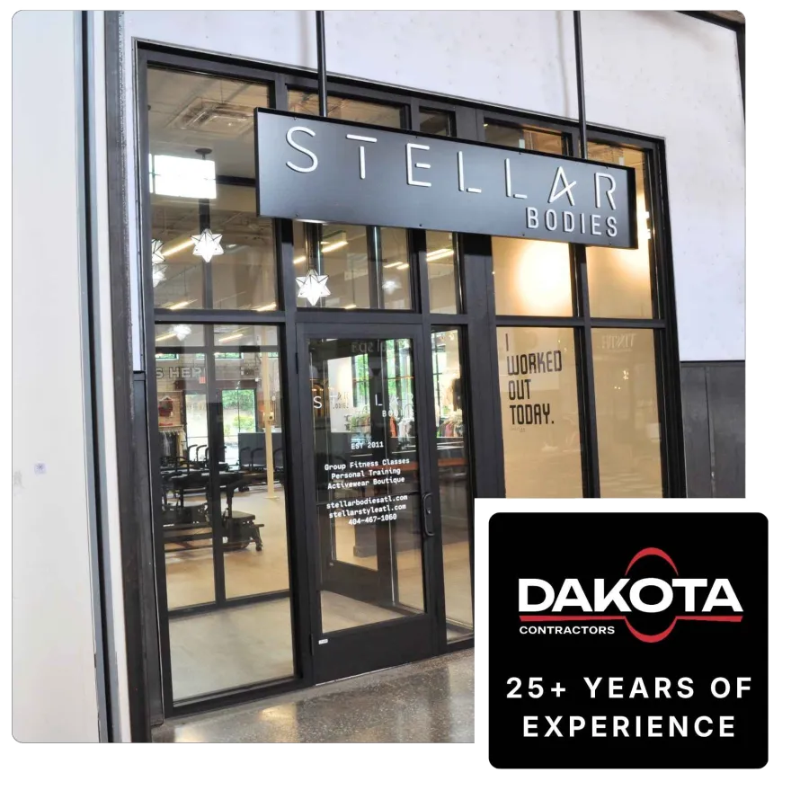 Entrance of Stellar Bodies fitness studio with glass doors, signage, and workout equipment visible inside.