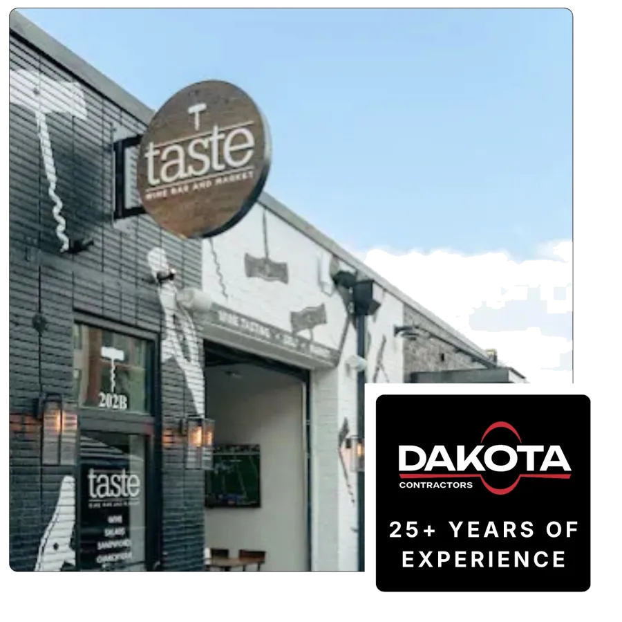 Exterior of Taste wine bar and market with black and white mural and wooden sign on a clear day
