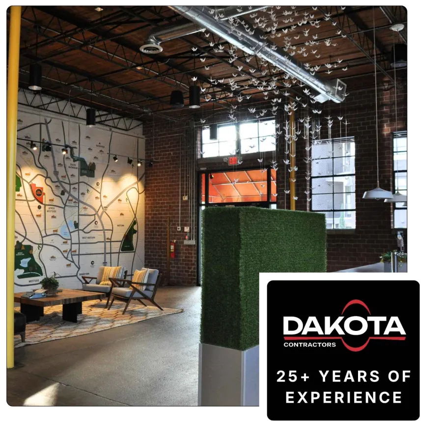 Modern industrial office interior with large wall map, wooden furniture, hanging paper cranes, and exposed brick walls.