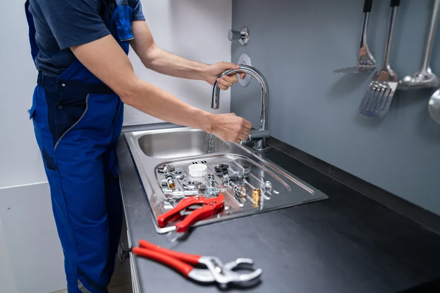 a man washing dishes in a sink