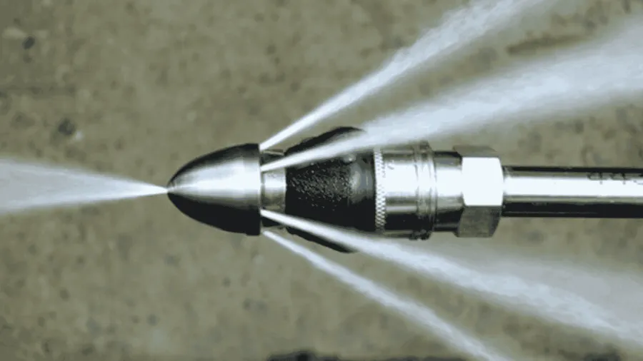 Close-up of a corroded, hollow pipe covered with dirt and roots on a white surface.