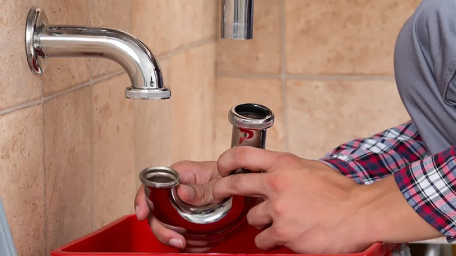 a person pouring a drink into a glass