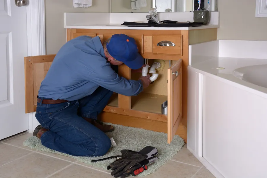 a person in a blue hat opening a cabinet