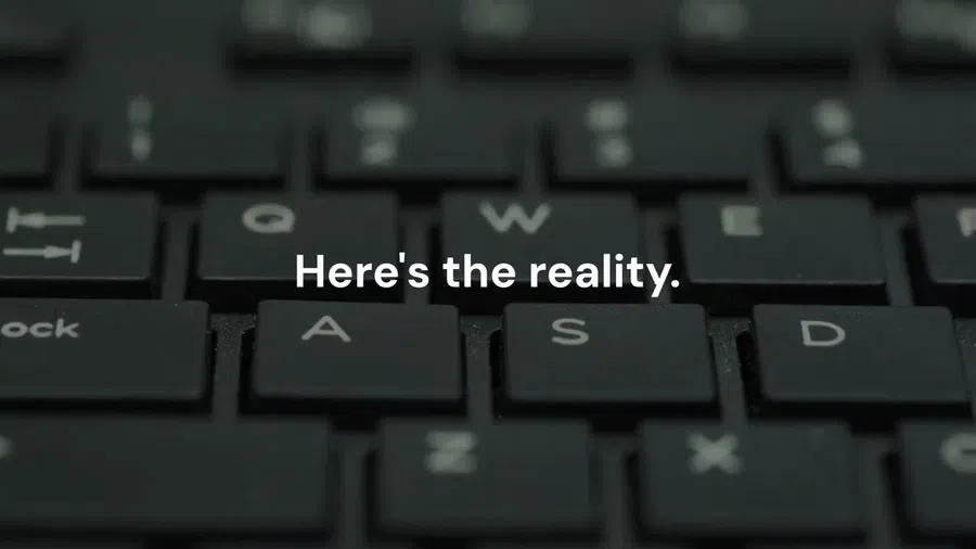 Close-up of black computer keyboard keys with white text overlay saying Here's the reality.
