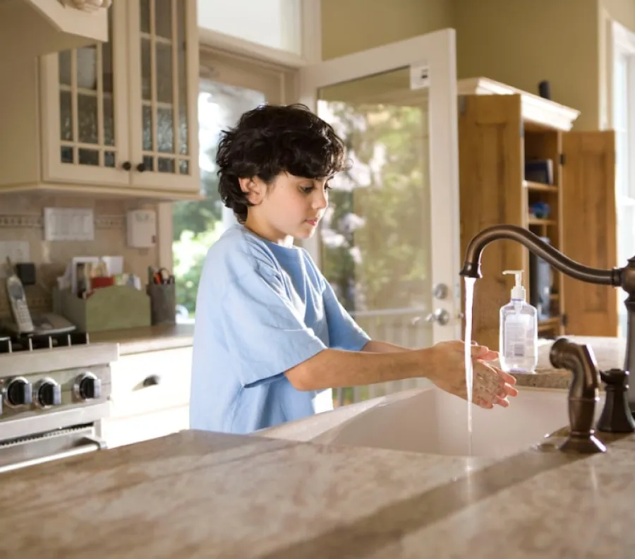 a child pouring a liquid into a faucet
