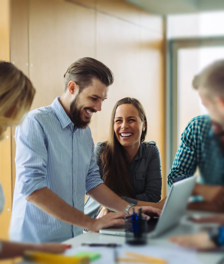 a group of people looking at a laptop