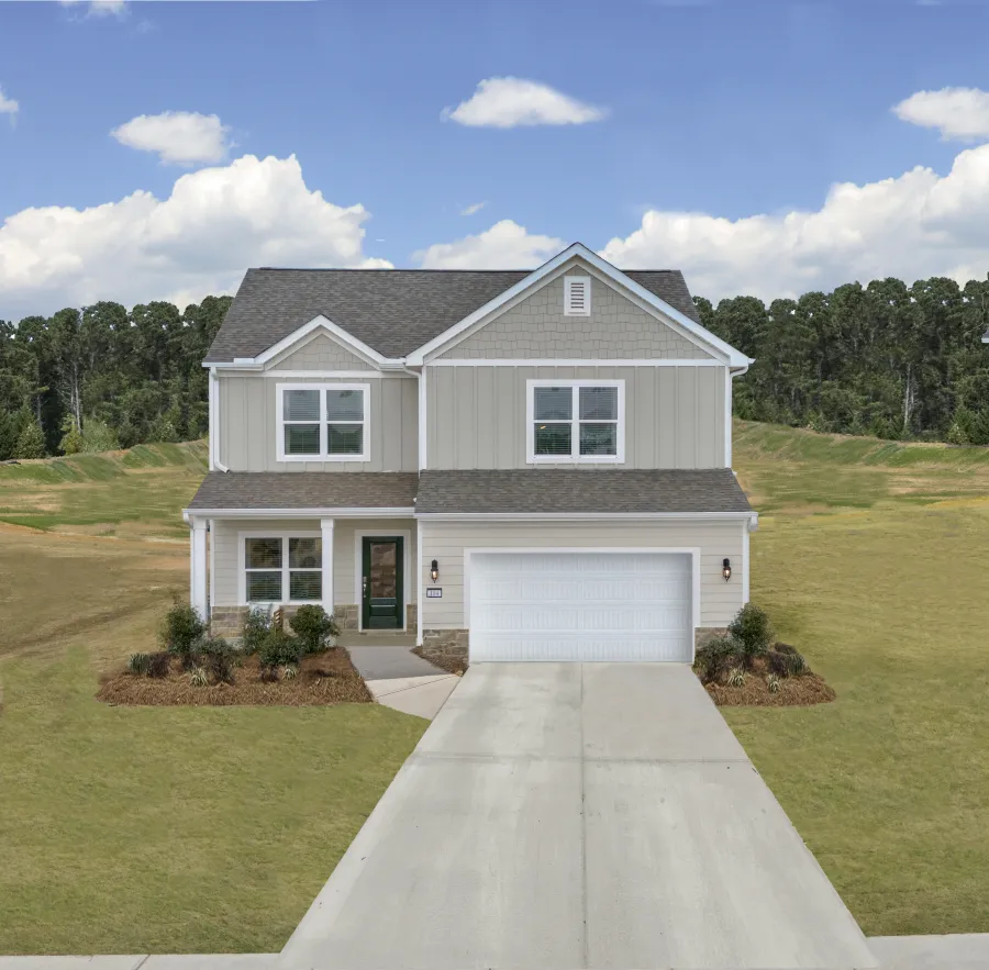 A beautiful two-story house with a green door, surrounded by a landscaped yard under a bright blue sky.