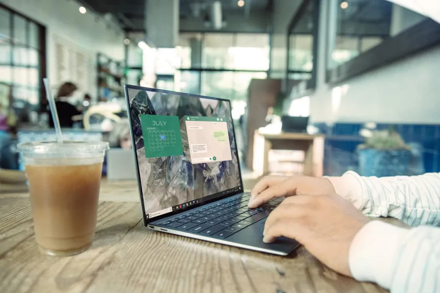 a person sitting at a table using a laptop computer