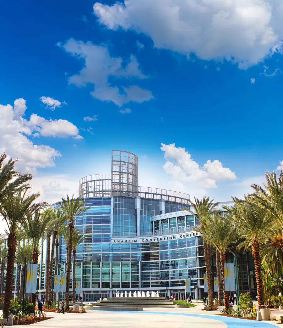 Modern Anaheim Convention Center with palm trees and blue sky on a sunny day