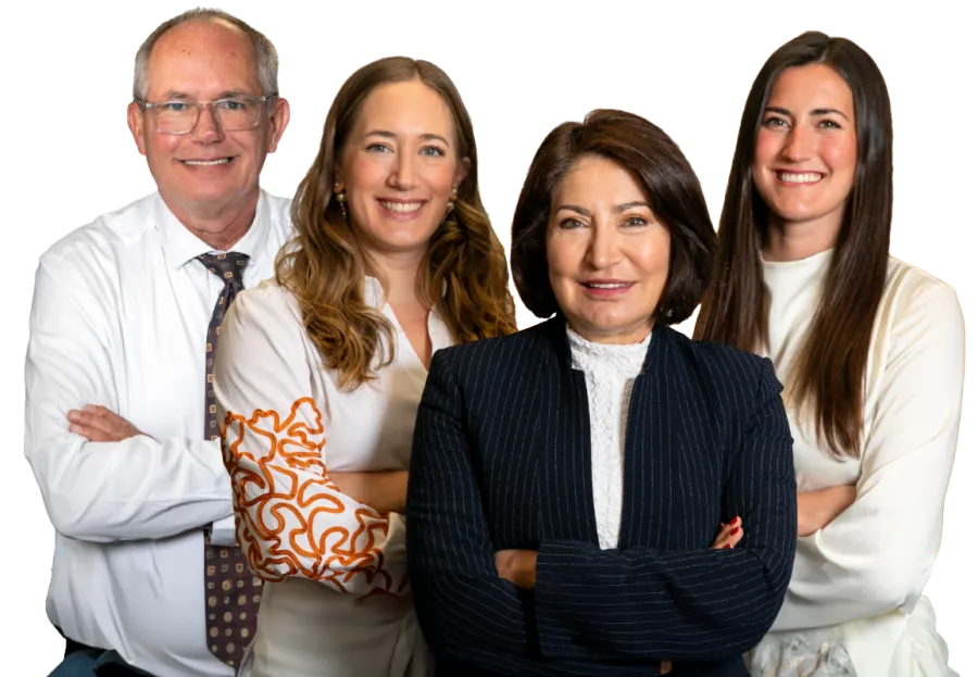 Four professionals smiling confidently with arms crossed against a white background.