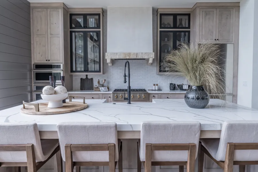 Modern kitchen featuring marble countertops, wooden cabinets, and stylish decor elements.