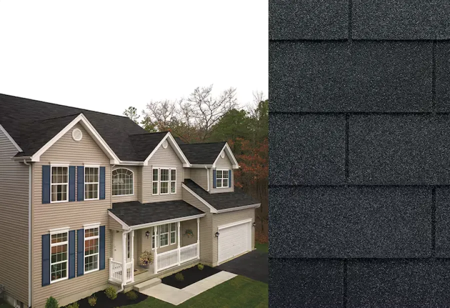 Modern two-story beige house with blue shutters and black asphalt shingle roof in a wooded area