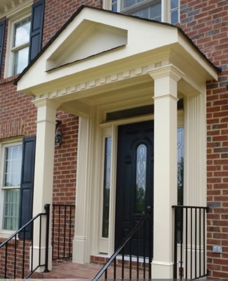 Elegant brick house entrance with a black door and classic columned porch design.