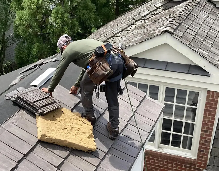 a couple of men working on a roof