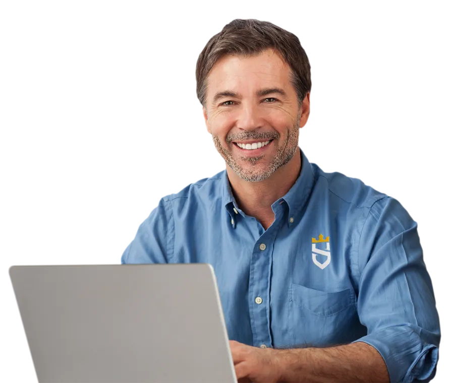 Smiling man in blue shirt working on silver laptop against white background