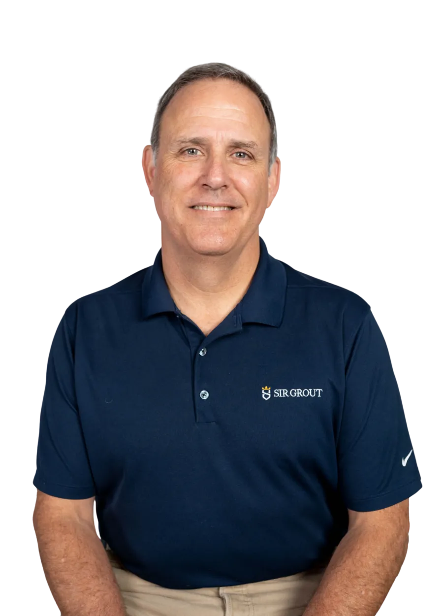 Middle-aged man wearing a navy Sir Grout polo shirt and smartwatch, smiling while seated