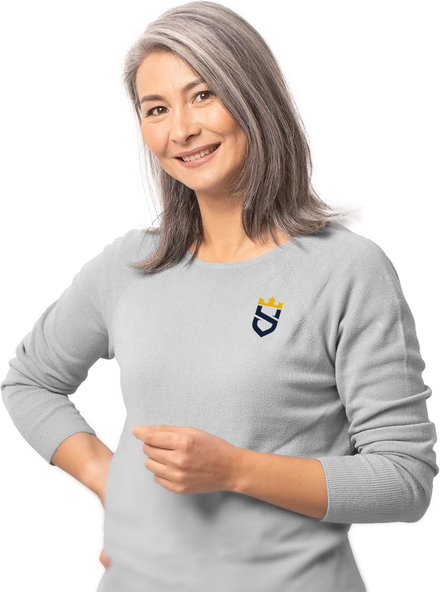 Smiling middle-aged woman with gray hair wearing light gray sweater with Sir Grout logo on chest posing with hand on hip.