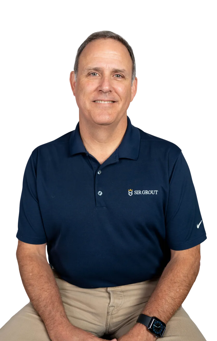 Middle-aged man smiling wearing navy Sir Grout polo shirt and beige pants with a smartwatch