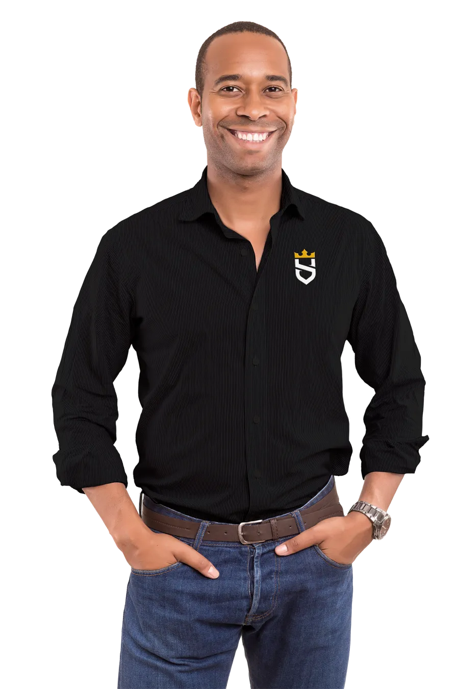 Smiling man wearing a black shirt with a crown logo, blue jeans, and a wristwatch, hands in pockets.