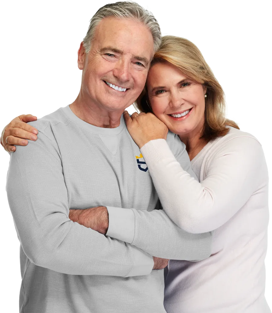 Smiling mature couple in casual clothes embracing and looking at camera with warmth and affection