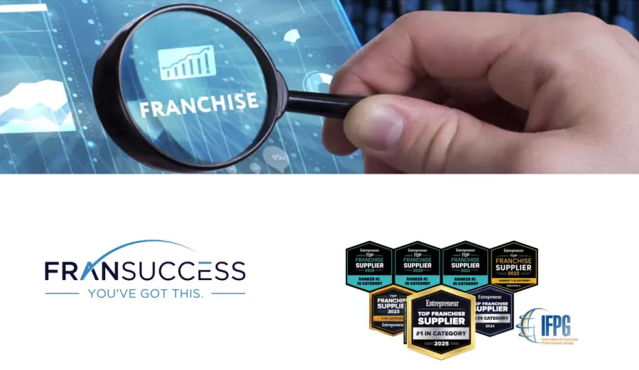 Hand holding magnifying glass over digital screen with franchise text and success badges below