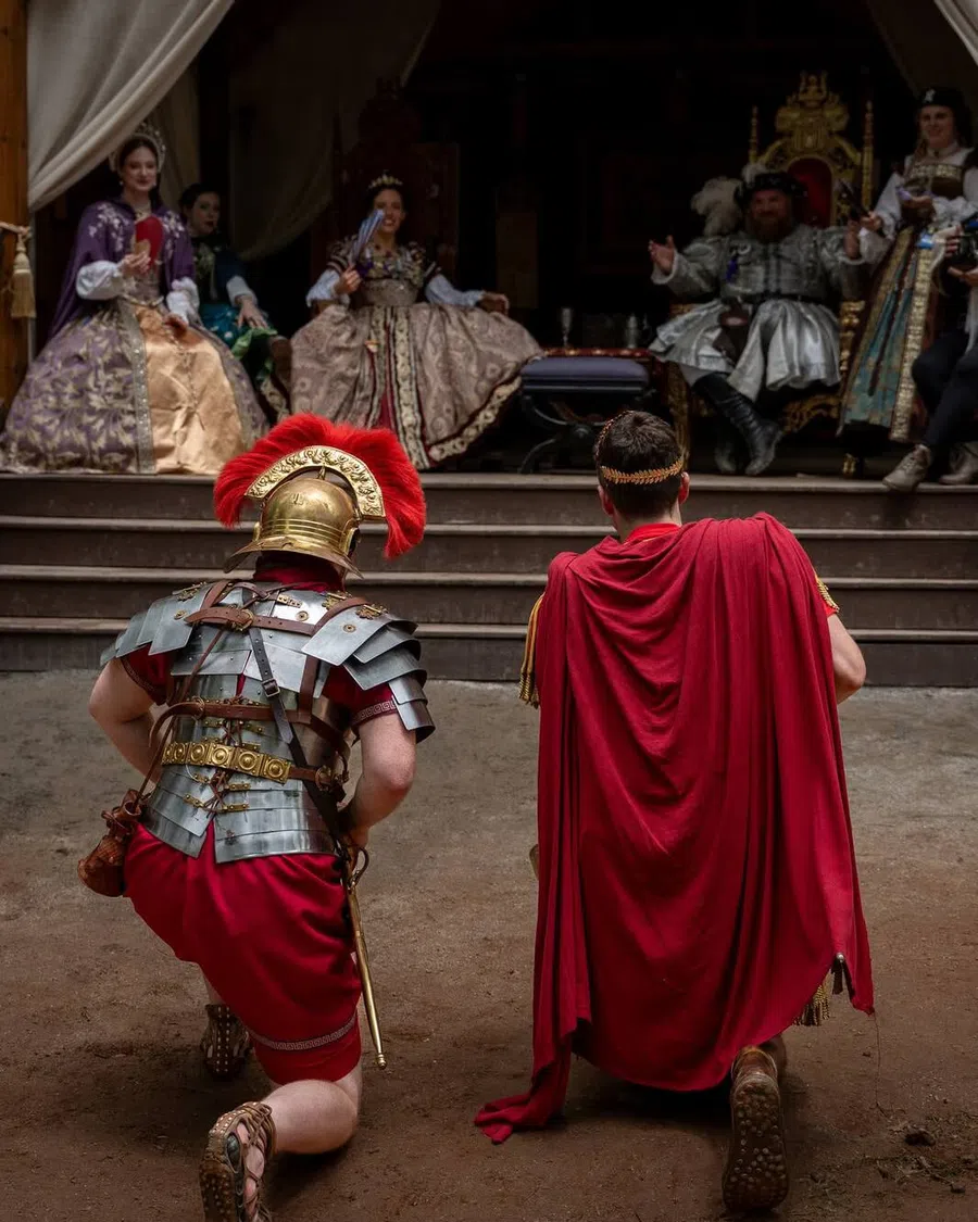 Performers in Roman costume kneeling before the royal court at the Festival.