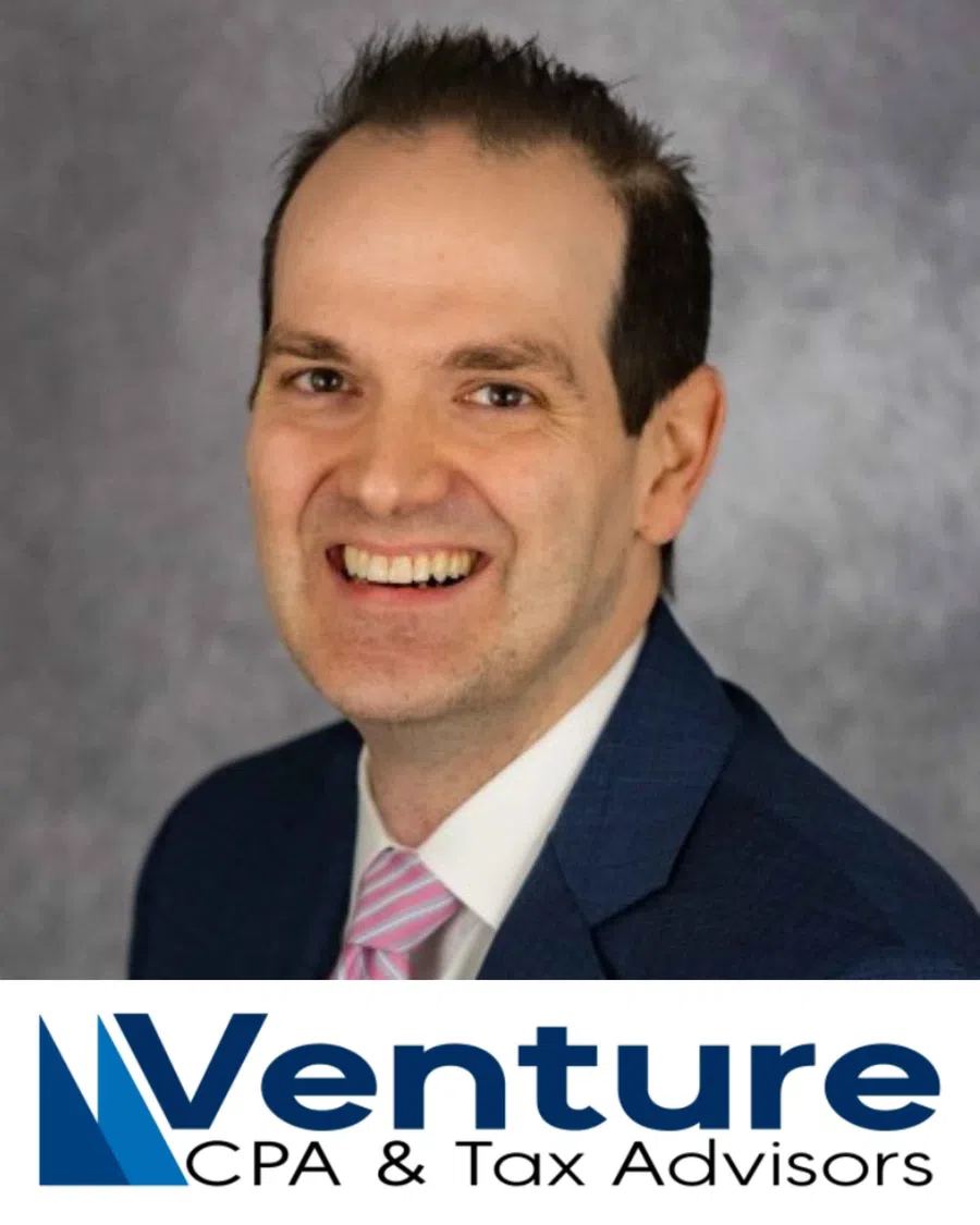 Smiling man in a blue suit and pink striped tie with Venture CPA & Tax Advisors logo below.