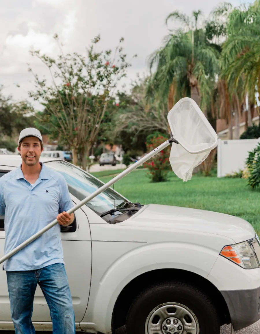 a man holding a white umbrella next to a car