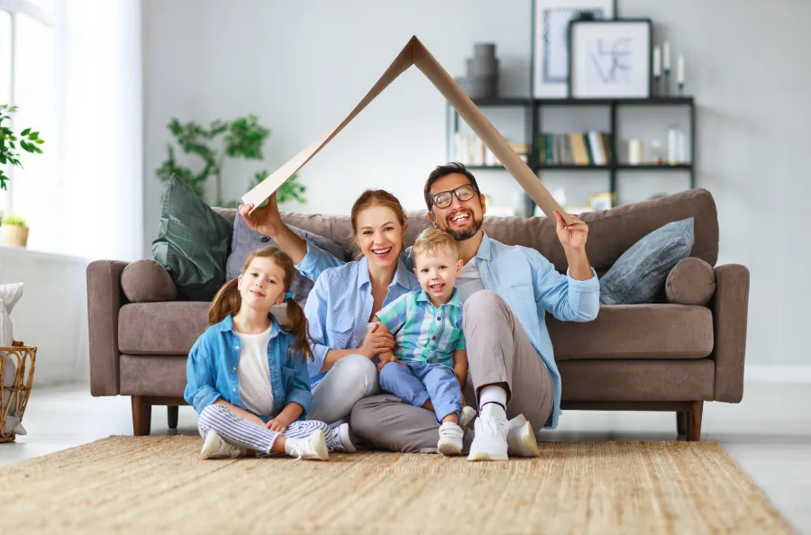 a person and two children sitting on a couch with a wooden object