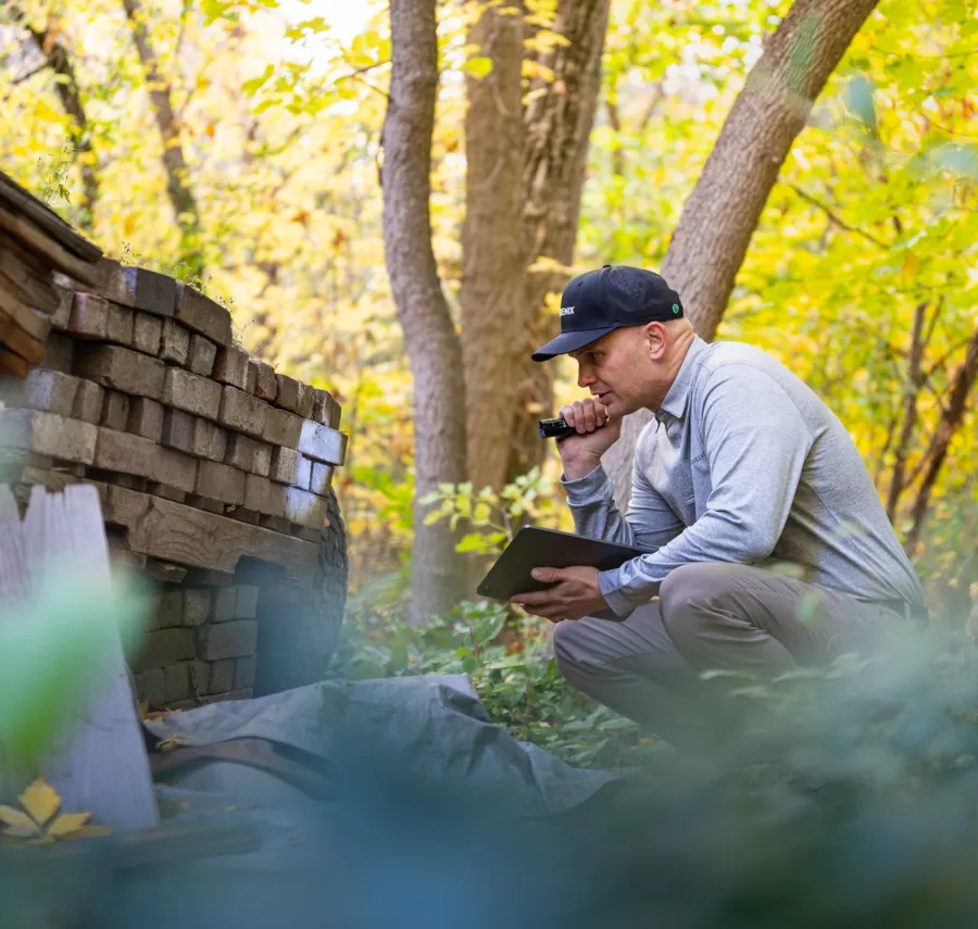 a man sitting on a log with a phone in his hand