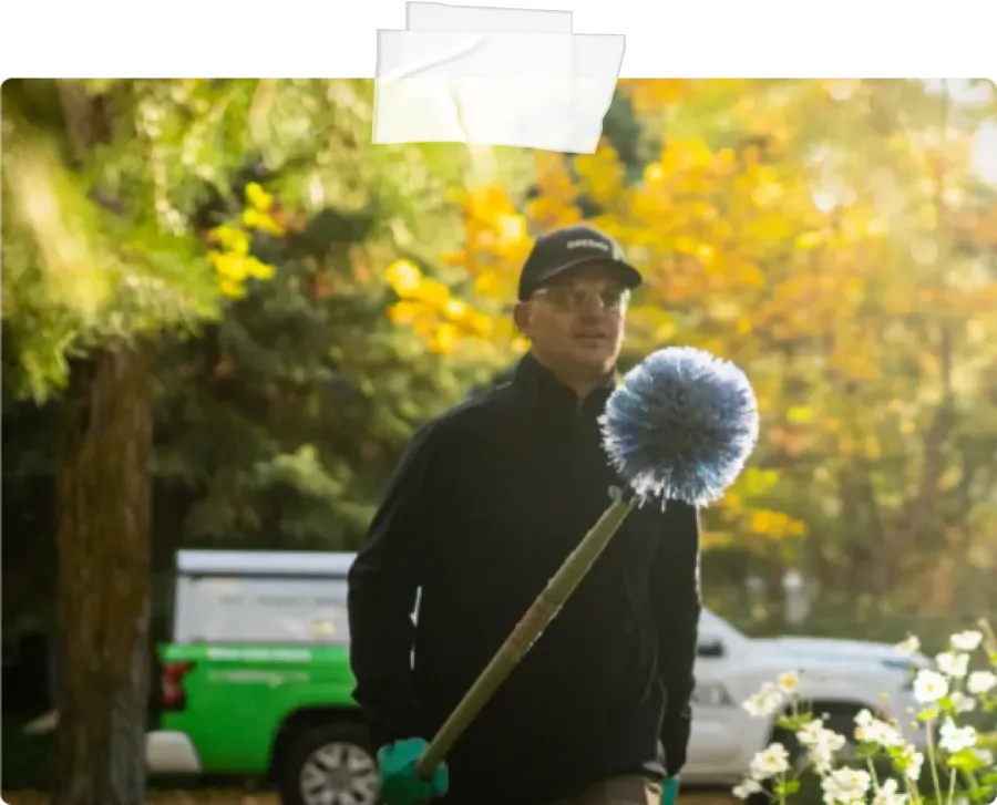 Pest Technician holding eave sweep brush