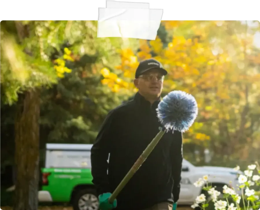 Pest Technician walking with eave brush