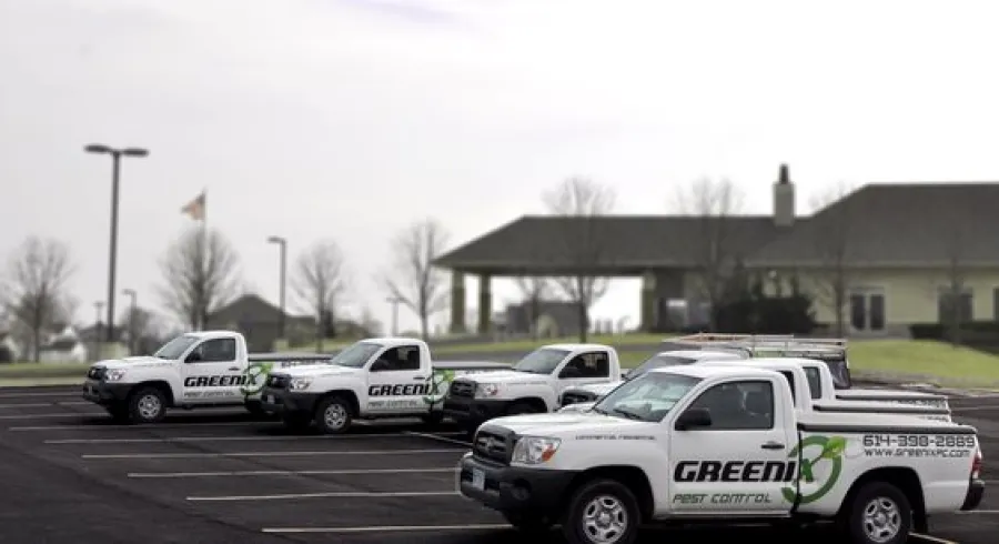 A group of old Greenix trucks in a parking lot