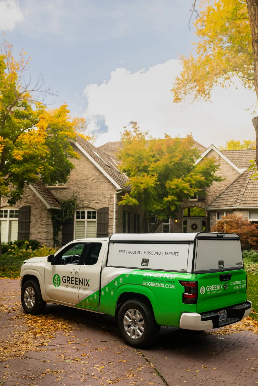 a green truck parked in front of a house