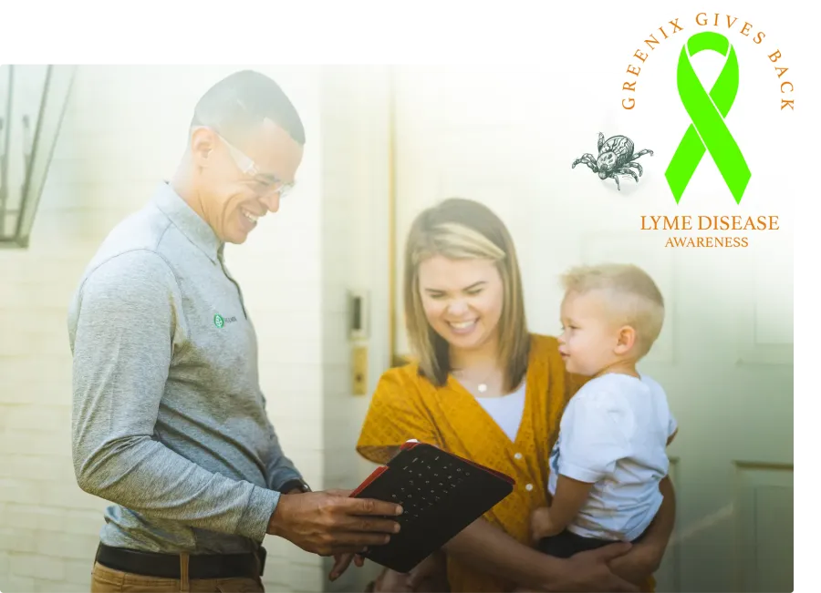 Smiling man showing a tablet to a woman holding a child with Lyme disease awareness ribbon logo in corner.
