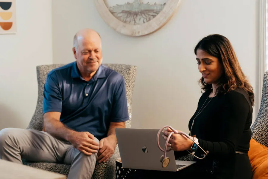 Ankita Patil et al. sitting on a couch looking at a laptop