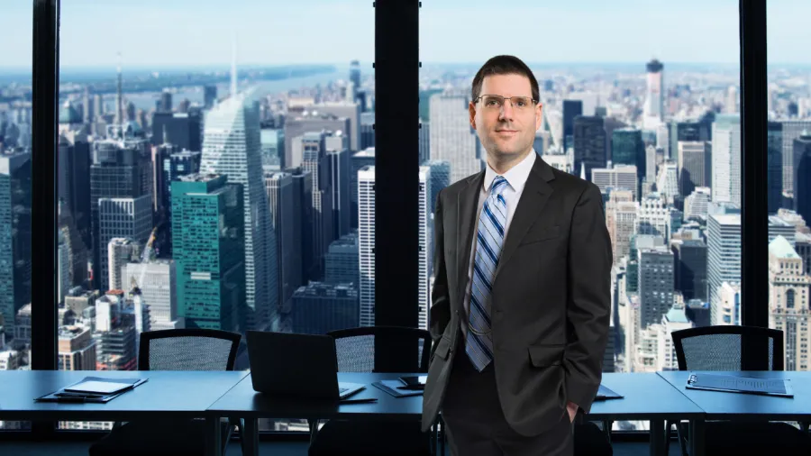 david standing in front of a window with a city skyline behind him