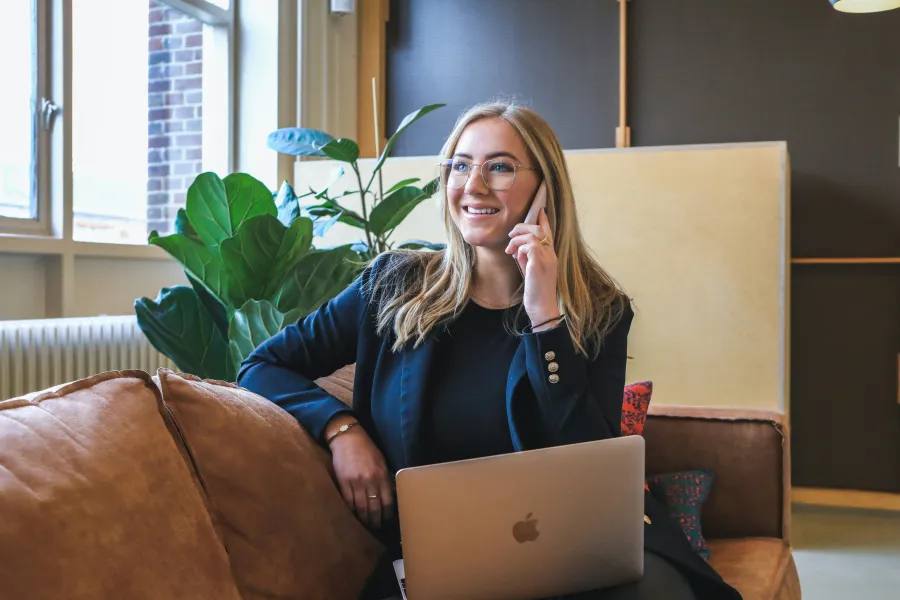 Kara Pacitto sitting on a couch with a laptop