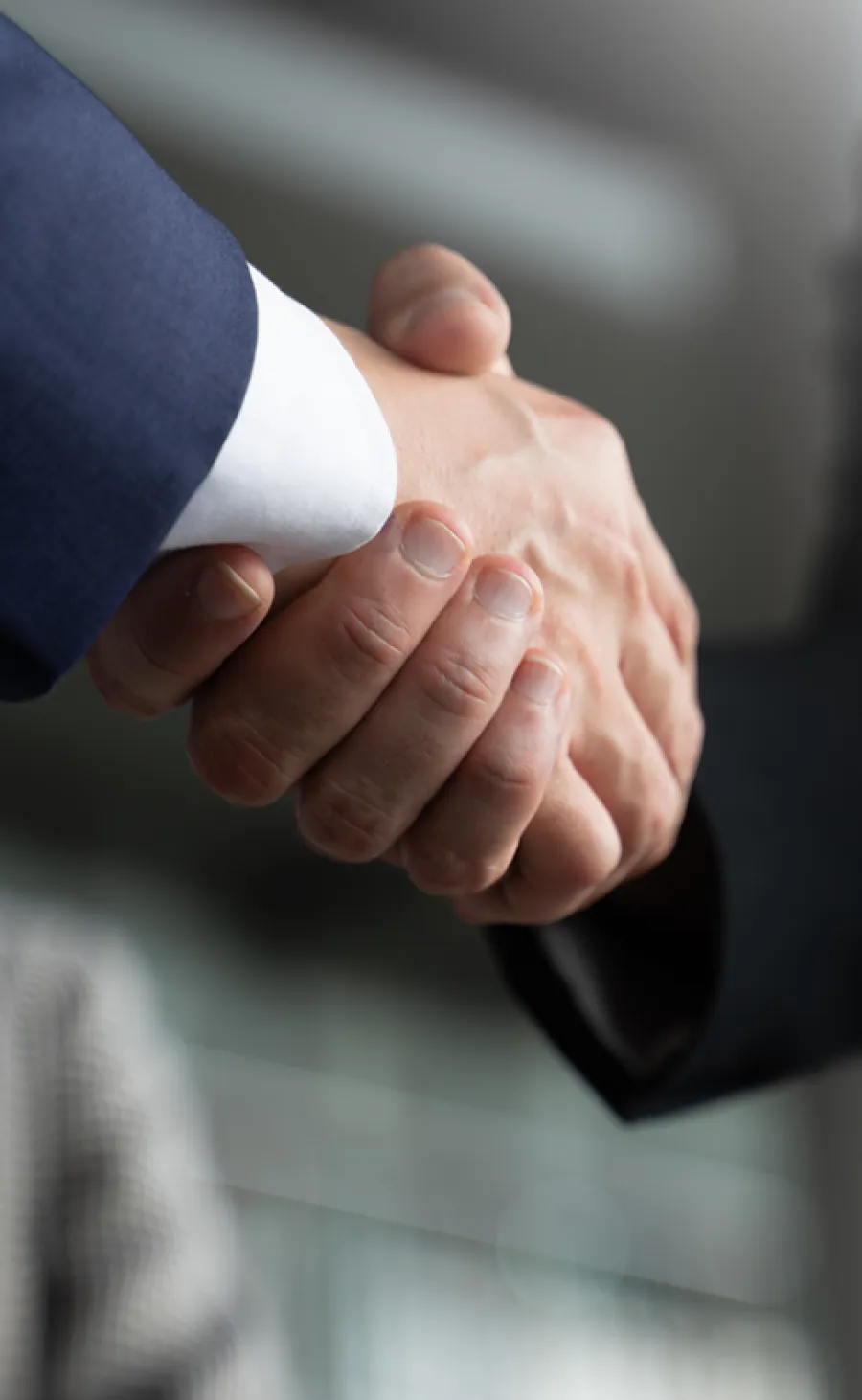 Close-up of two business professionals shaking hands as a symbol of agreement and partnership